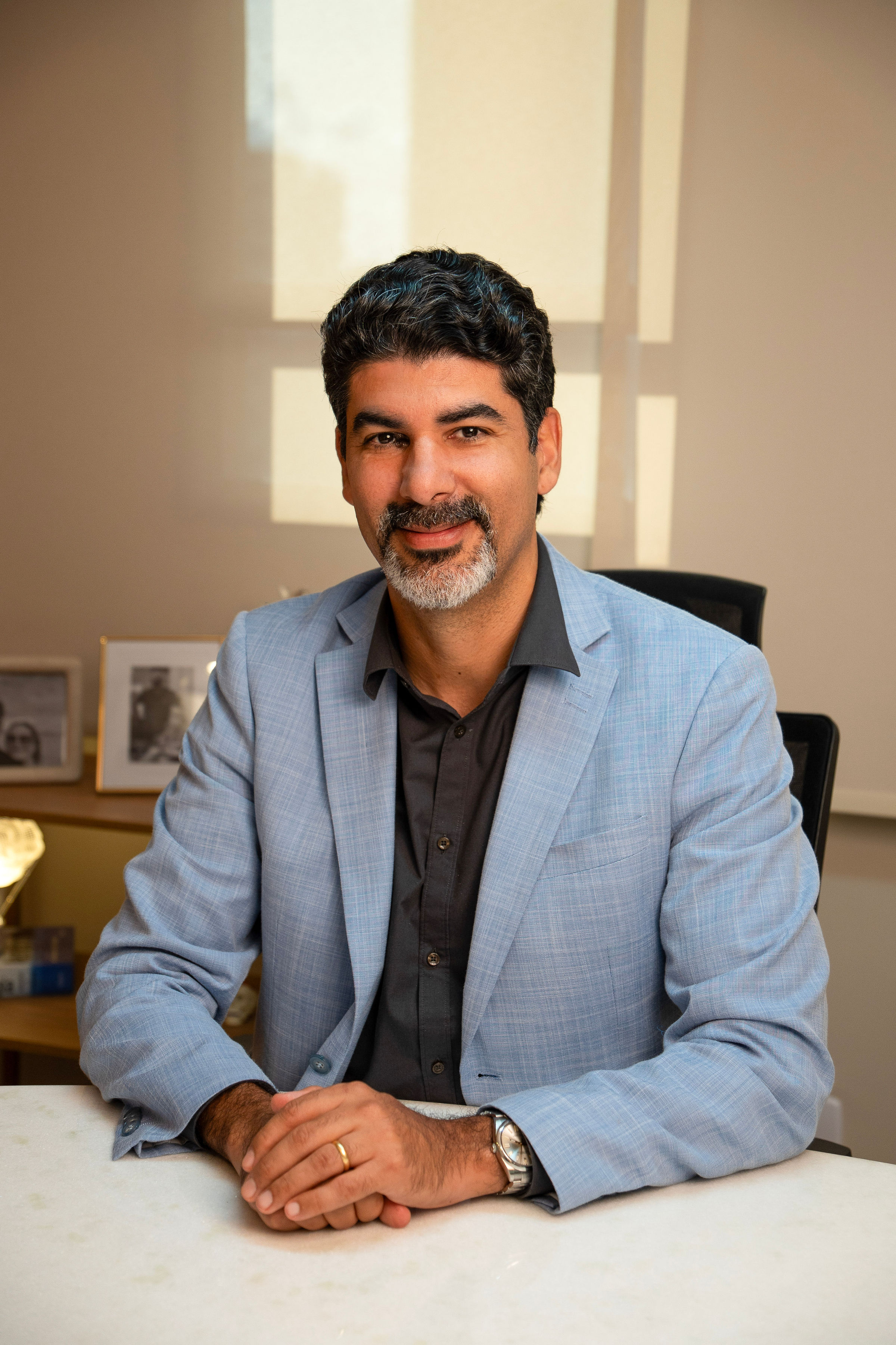 Retrato do Dr. Chrystiano Cardoso sorrindo, em seu consultório